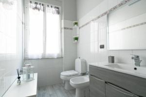 a white bathroom with a toilet and a sink at Ele's apartment in La Spezia