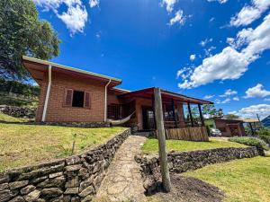 una casa con una pared de piedra delante de ella en Casa Primavera, en São Bento do Sapucaí 40 fotos más