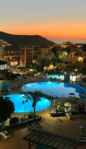 a view of a large swimming pool at night at Sunny terrace & pool in Playa de las Americas