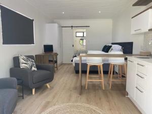 una stanza con un letto, un tavolo e delle sedie di Zonnekus Guesthouse a Città del Capo