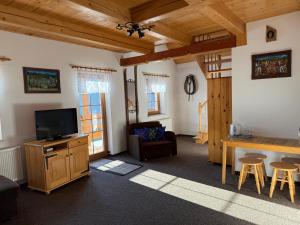 een woonkamer met een televisie en een tafel bij Dom Madeyski in Szczawnica