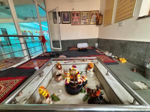 a room with a table with figurines in it at Shri Gaya Prasad Dham in Vrindāvan