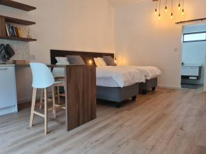 una camera da letto con un letto, un tavolo e una sedia di Zonnekus Guesthouse a Città del Capo