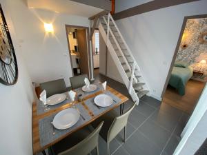 a dining room with a table and chairs and a staircase at Calme et Tranquille in Castelnau-dʼEstrétefonds