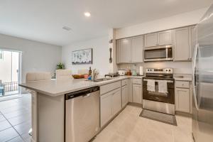 a kitchen with white cabinets and stainless steel appliances at Davenport Home w/ Pool Access & Patio! in Davenport