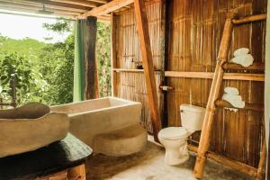 a bathroom with a bath tub and a toilet at Toucan Lodge in Puyo +66 photos