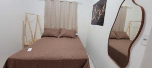 a small room with a bed and a mirror at kitnet in Rio Verde