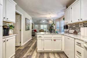a kitchen with white cabinets and wooden floors at Sparkling Waters in Pigeon Forge