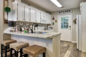 a kitchen with white cabinets and a sink and stools at Sparkling Waters in Pigeon Forge +25 photos