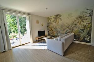 a living room with a couch and a wall mural at Appartement de la Pévèle in Wahagnies