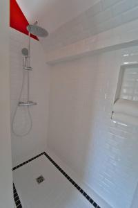 a white bathroom with a shower with a red light at Appartement de la Pévèle in Wahagnies