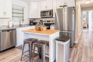 une cuisine avec un réfrigérateur en acier inoxydable et des tabourets dans l'établissement Cottage in the Pines, à Dauphin Island