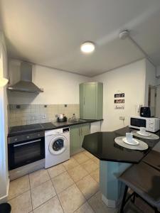 a kitchen with a stove and a washer and dryer at Mary Street Apartment in Galway