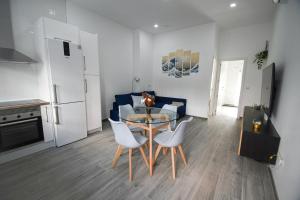 a living room with a table and chairs and a kitchen at Modern Oasis in Vallecas in Madrid