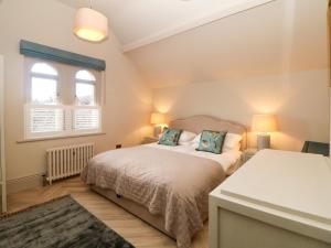 a bedroom with a bed and two windows at Chatsworth Suite in Buxton