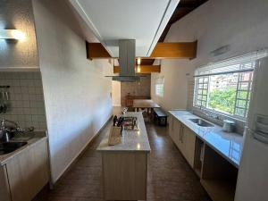a large kitchen with a sink and a counter at Casa com churrasqueira in Poços de Caldas +20 photos