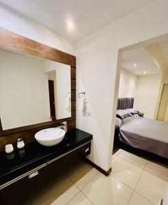a bathroom with a sink and a bed and a mirror at DELUXE Apartamento Urbano in Santa Cruz de la Sierra