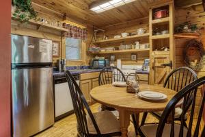 a kitchen and dining room with a table and a refrigerator at Tennessee Twilight Cabin in Sevierville