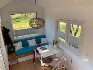 a living room with a blue couch and two windows at Gemütliches Tiny House in der Rhön in Hilders