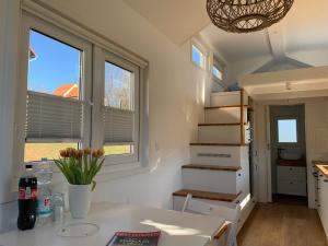 Gemütliches Tiny House in der Rhön في Hilders: منزل صغير به درج ونافذتين +15 صورة