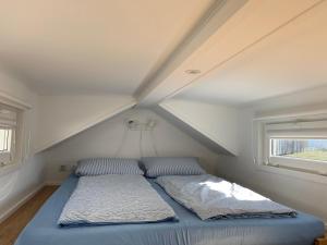 Gemütliches Tiny House in der Rhön في Hilders: سرير في غرفة صغيرة مع سقف