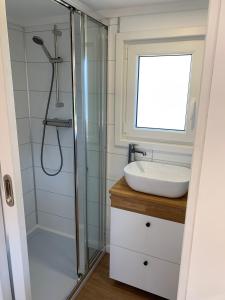 Gemütliches Tiny House in der Rhön في Hilders: حمام مزود بمغسلة ودش