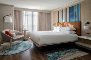 圣彼得堡圣彼得堡克利尔沃特万豪酒店的配有一张大床和一把椅子的酒店房间