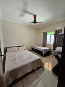 a bedroom with a bed and a ceiling fan at Refúgio verde in Itatiaia