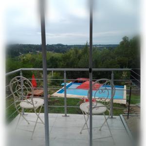 a balcony with two chairs and a table and a pool at La Cumbre in Sierra de los Padres