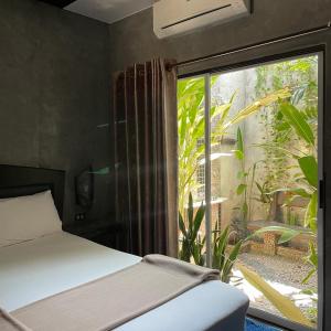 a bedroom with a bed and a large window at บ้านณัฐวรรณ หัวหิน - Baan Nattawan Huahin in Hua Hin