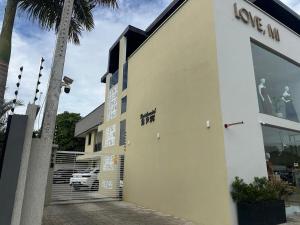 a white building with a car parked in a parking lot at Novo e Moderno Apartamento in Boa Vista