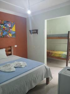 a bedroom with a bed and a painting on the wall at Pousada Aconchego do Porto in Porto De Galinhas