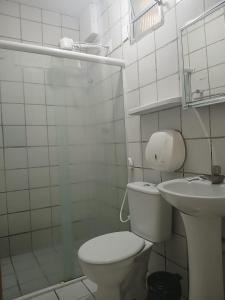 a white bathroom with a toilet and a sink at Pousada Aconchego do Porto in Porto De Galinhas