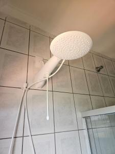 a white shower head hanging from a ceiling at Refúgio verde in Itatiaia +21 photos