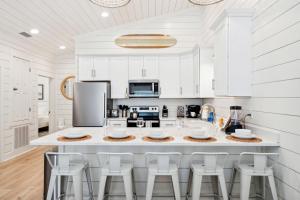 a kitchen with white cabinets and a large island with stools at Brand New Luxury Rental on Oleander Unit A in Dauphin Island
