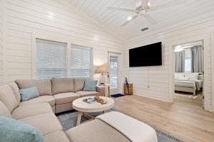 a living room with a couch and a tv at Brand New Luxury Rental on Oleander Unit A in Dauphin Island
