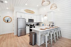 a kitchen with white cabinets and a large island with bar stools at Brand New Luxury Rental on Oleander Unit A in Dauphin Island +24 photos