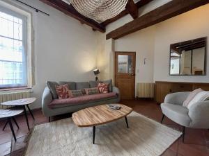 a living room with a couch and a coffee table at L'Arlésienne des Arènes in Arles