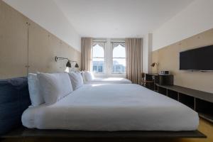 a hotel room with two beds and a television at STILE Downtown Los Angeles by Kasa in Los Angeles