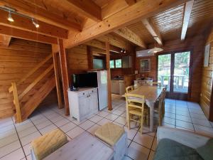a kitchen and dining room of a log cabin at Chalet en bois in Bias
