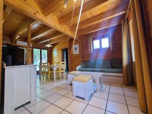 a room with a bed and a kitchen and a table at Chalet en bois in Bias