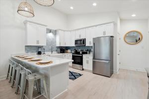 una cucina con armadi bianchi e frigorifero in acciaio inossidabile di Brand New Luxury Rental on Oleander Unit G a Dauphin Island