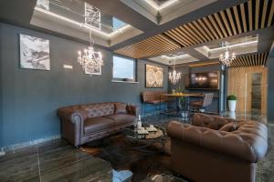 a living room with two leather couches and a table at Luxury Villa Karmen with pool & spa zone in Ričice