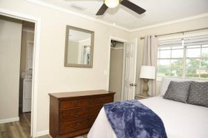 1 dormitorio con 1 cama con ventilador de techo y espejo en Bungalow near Main Street - #1, en Grand Bay 11 fotos más