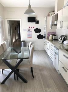 a kitchen with a glass table and some chairs at Casas do Convento in Minde