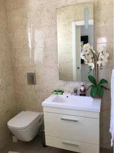 a bathroom with a sink and a toilet and a mirror at Casas do Convento in Minde