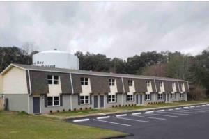a large white building with a silo next to a road at Townhomes Near the Bay - #1 in Grand Bay +2 photos
