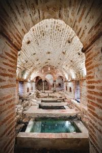 an old building with a pool in the middle at Casale Valle Agnese in Godrano