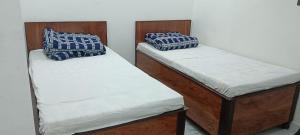 2 camas individuales en una habitación con 3 camas individuales que establece que en Malik kripa Home stay, en Prayagraj