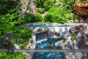 two people swimming in a swimming pool in a waterfall at Le Plein Sud - Your ideal getaway by Lake Lise in Chertsey +45 photos
